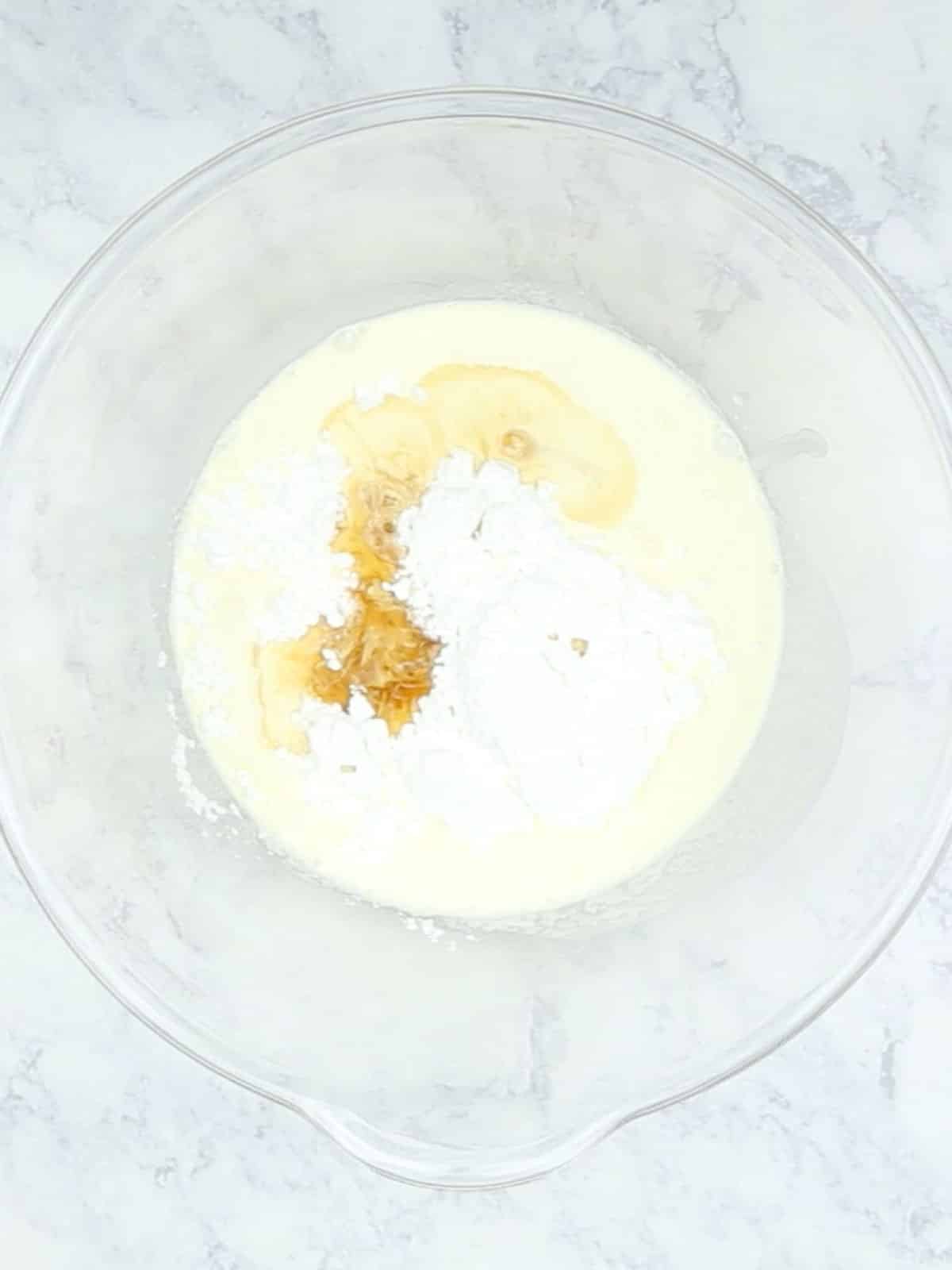 Whipped cream ingredients in a glass bowl.