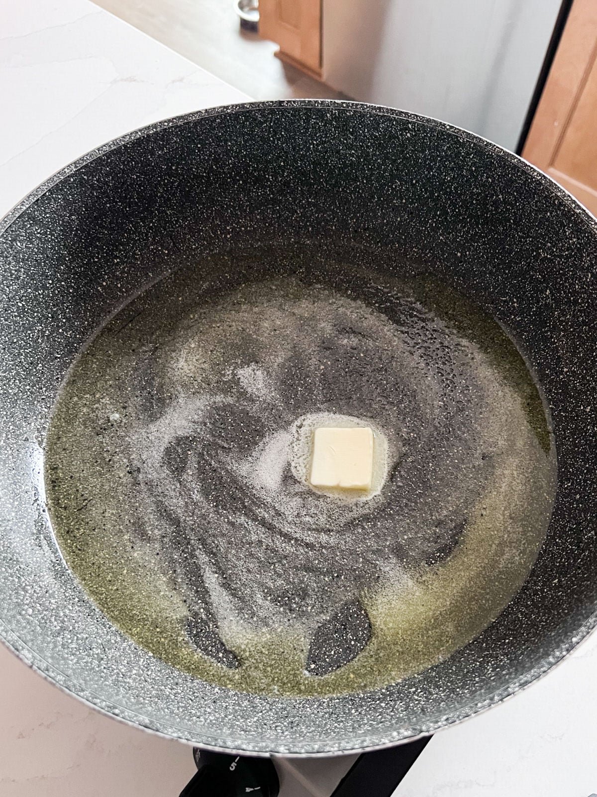 Butter melting in a hot skillet.