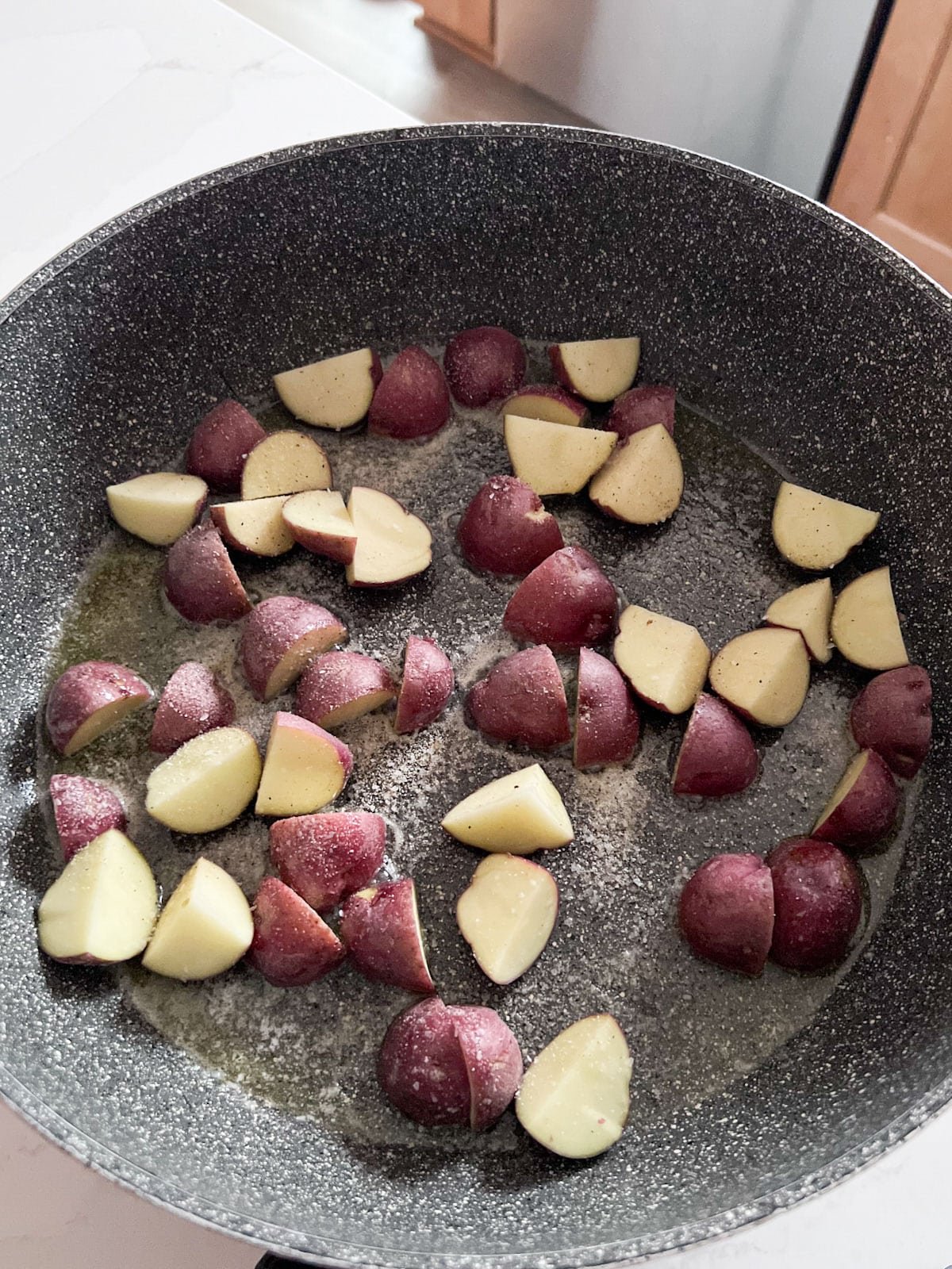 Potatoes added to the butter in the skillet.