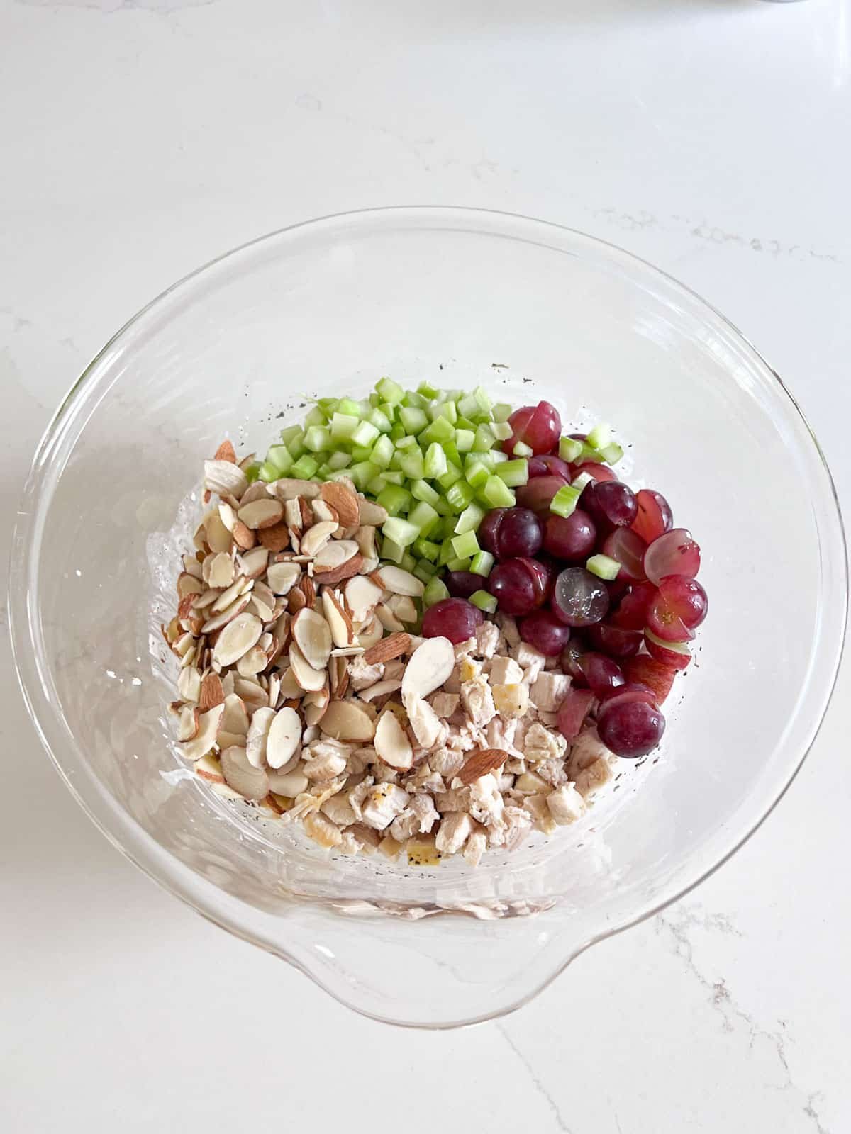 Chicken, almonds, celery and grapes added into the bowl.