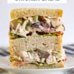Two halves of a chicken salad sandwich piled on top of each other revealing the inside of the sandwich.