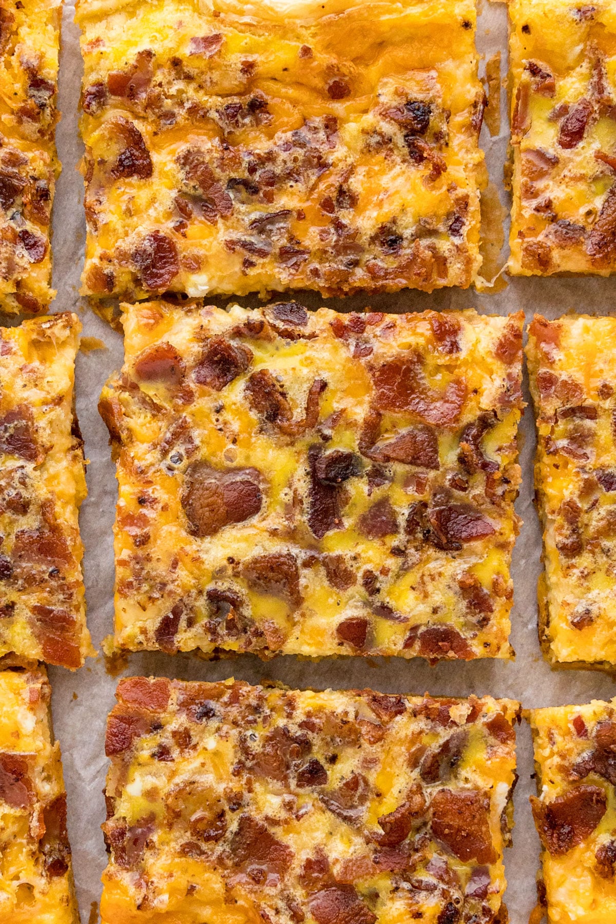 A close up overhead image of slices of breakfast pizza next to each other.