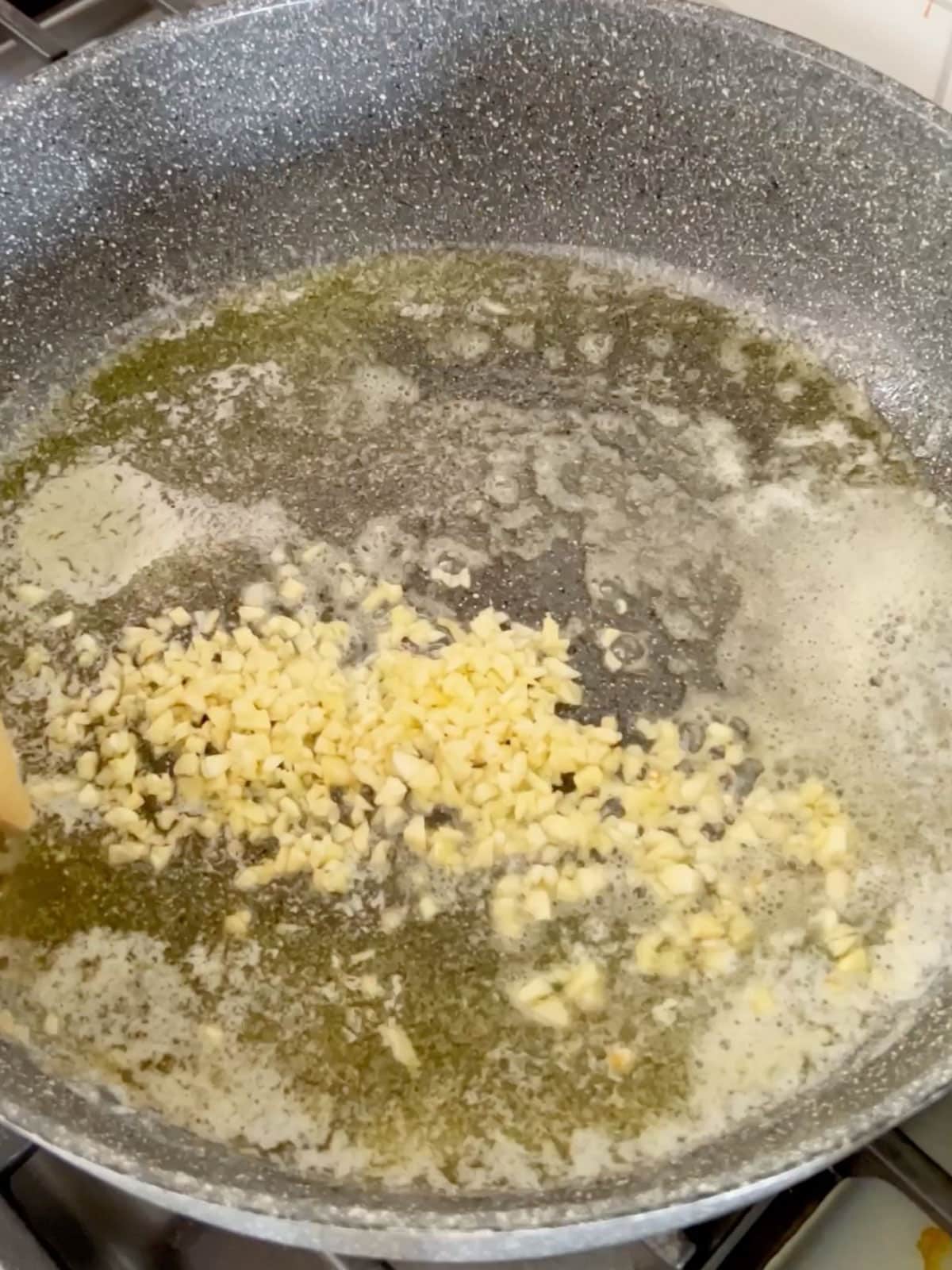 Minced garlic added to the skillet.