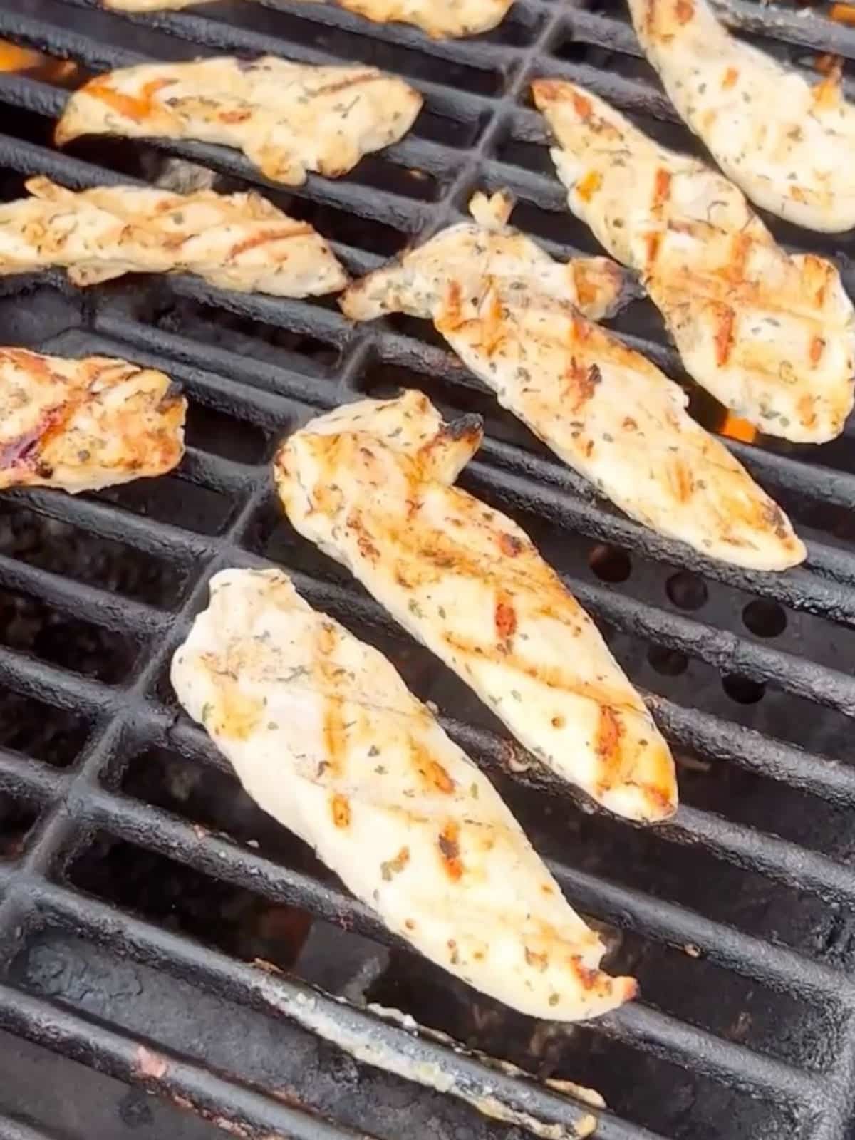 Chicken pieces being cooked on a grill.
