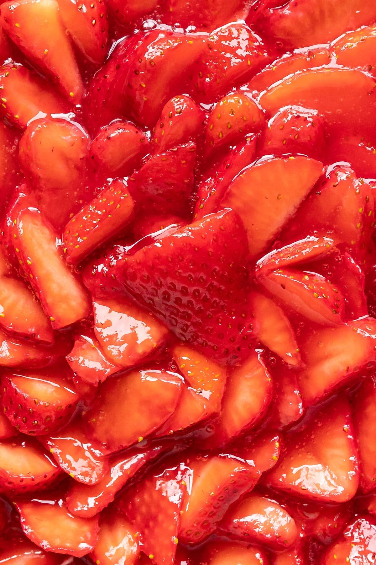 A close up image of the strawberries shingled on top of the pie.