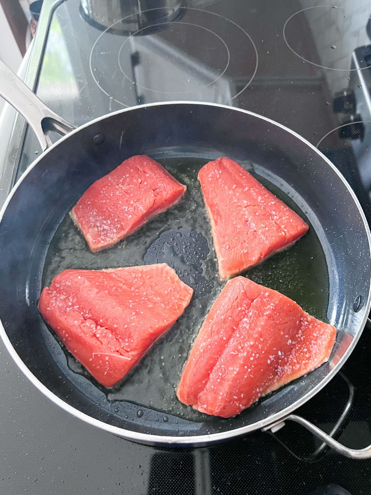 Salmon searing in oil.