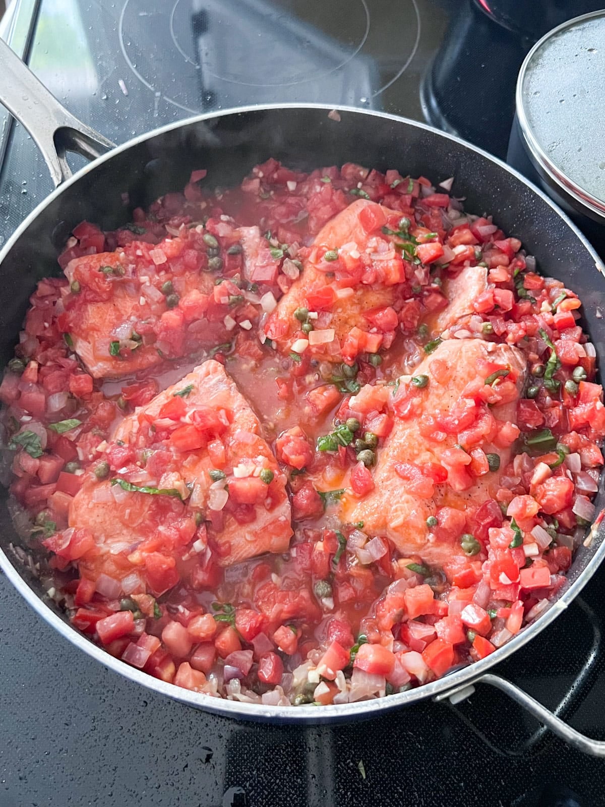 Salmon and basil nestled into the tomato mixture.