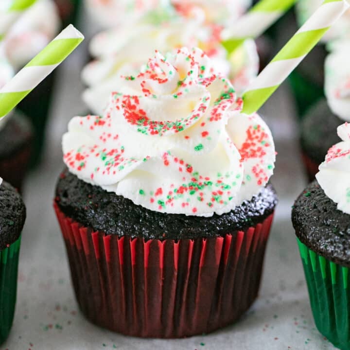 A hot cocoa cupcake with others lined up behind and around it.