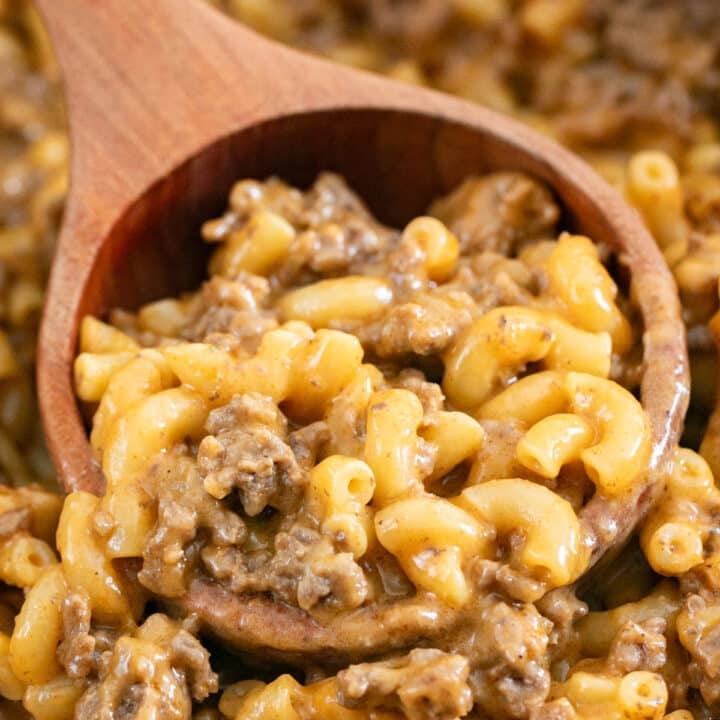 A close up image of a wooden spoon in a pan of homemade hamburger helper.