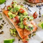 A filet of baked chili salmon with avocado salsa on top