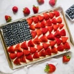 An overhead image of an American Flag Pizza with berries around it.