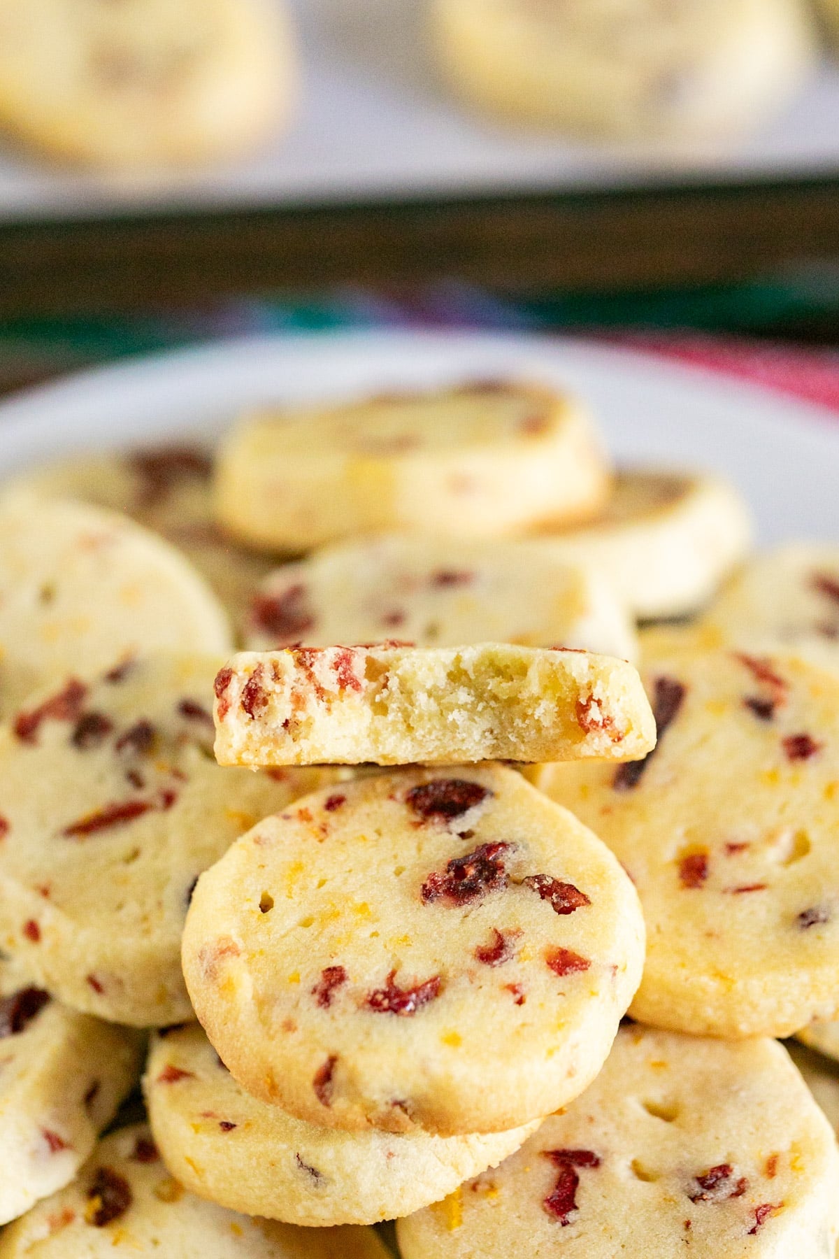 A pile of shortbread cookies with a bite taken out of one revealing a crumbly interior.