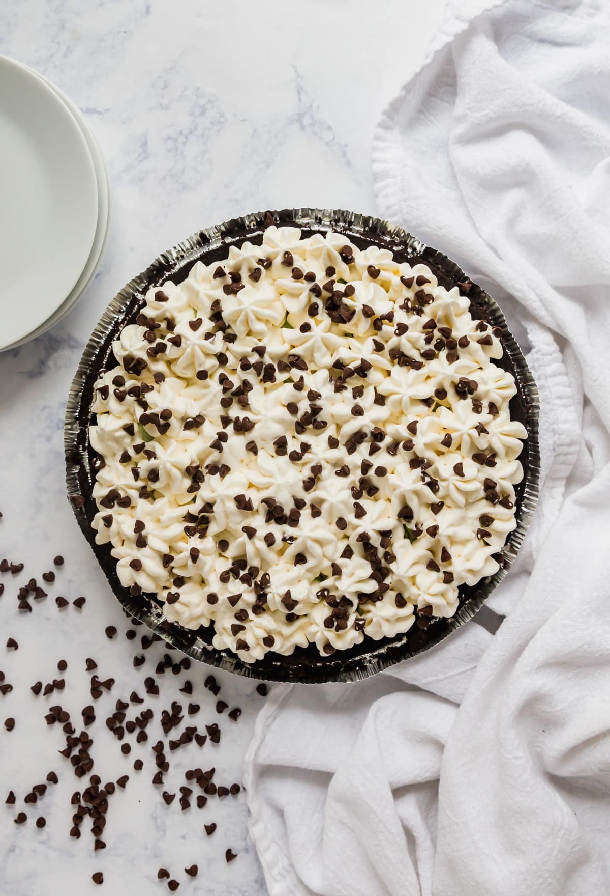 An overhead image of a peppermint pie with chocolate chips around it and on top.