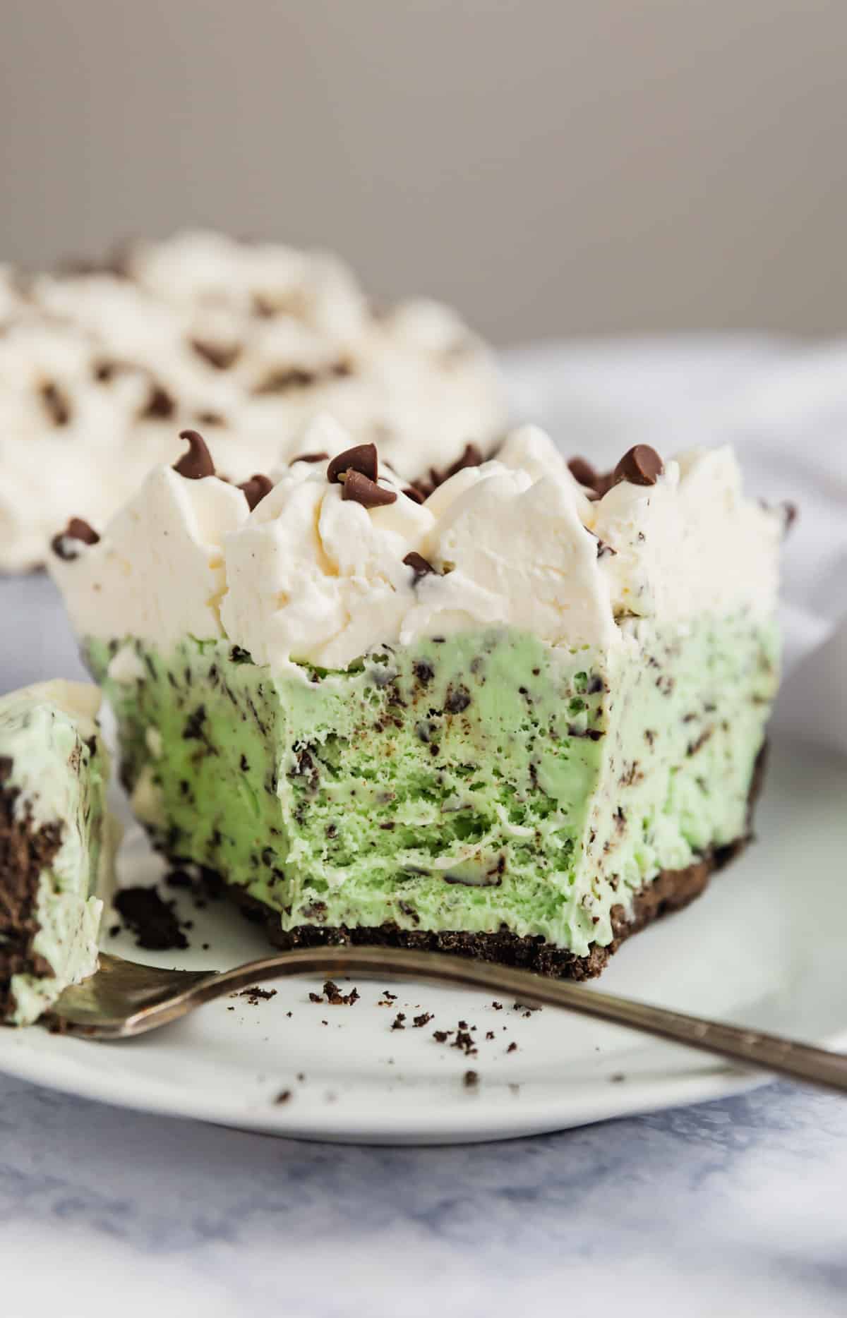 A straight on image of ice cream pie with a bite taken from it.