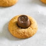 A close up image of a caramel blossom cookie on a pan.
