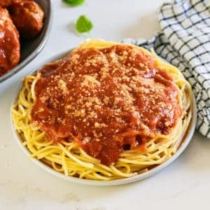 A plate of spaghetti with meat sauce on top of it.