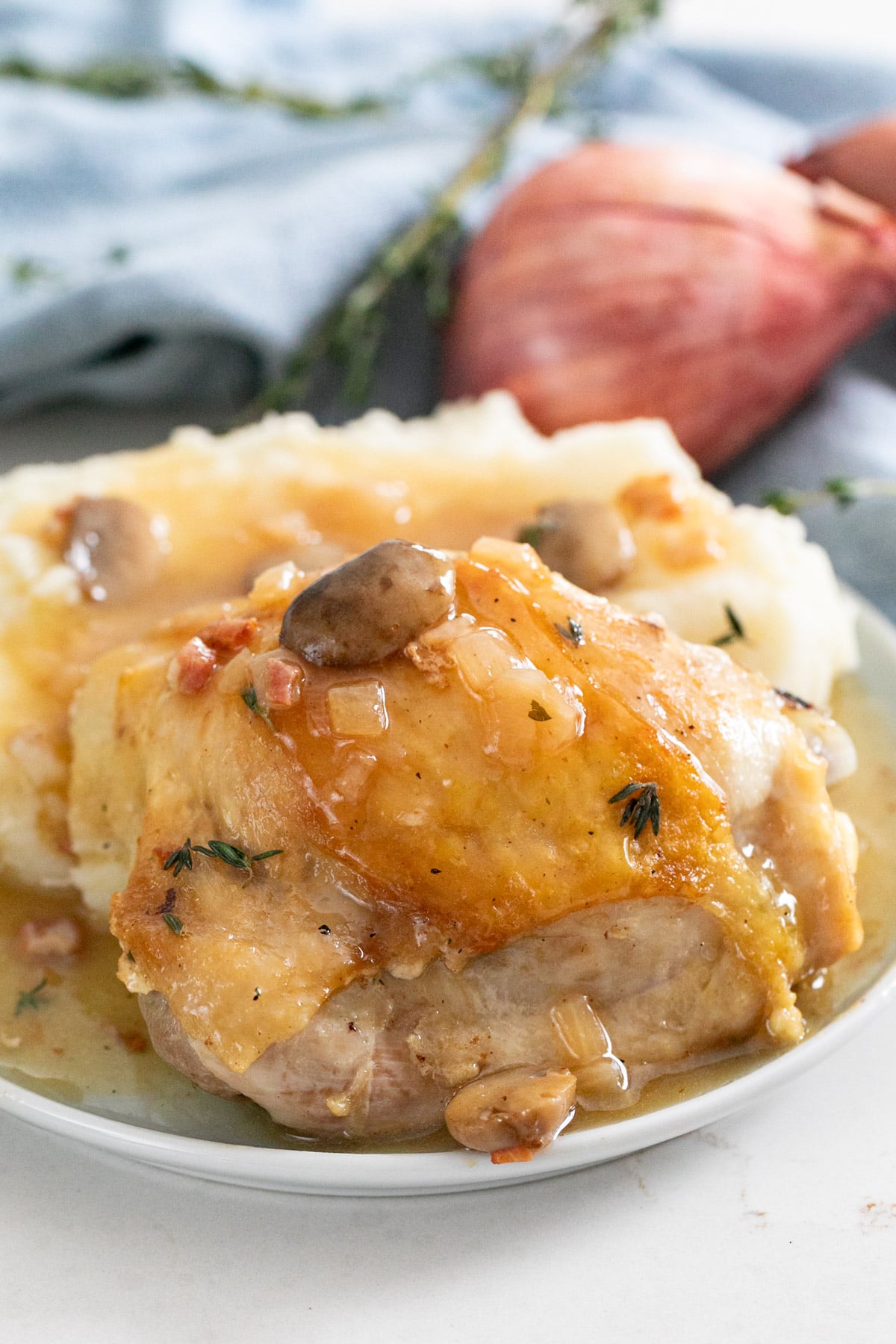 A close up of a perfectly cooked chicken thigh on a plate.