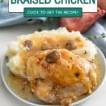 Champagne braised chicken on a plate with mashed potatoes.