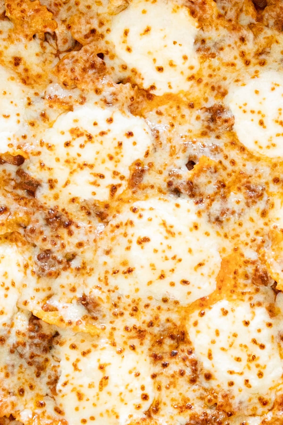 A close up overhead image of the top of the pasta covered in melty cheese.