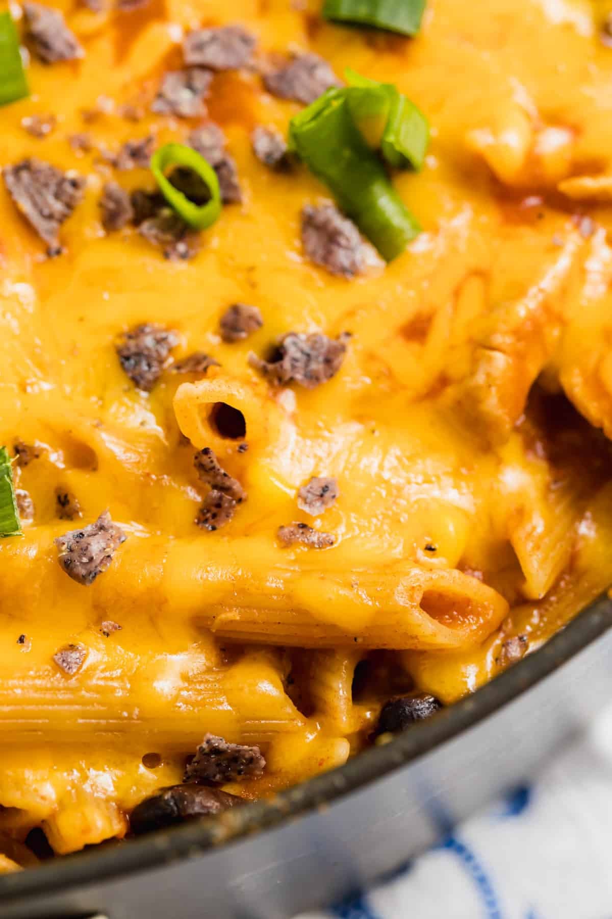 A close up of pasta with melted cheese in the pan.