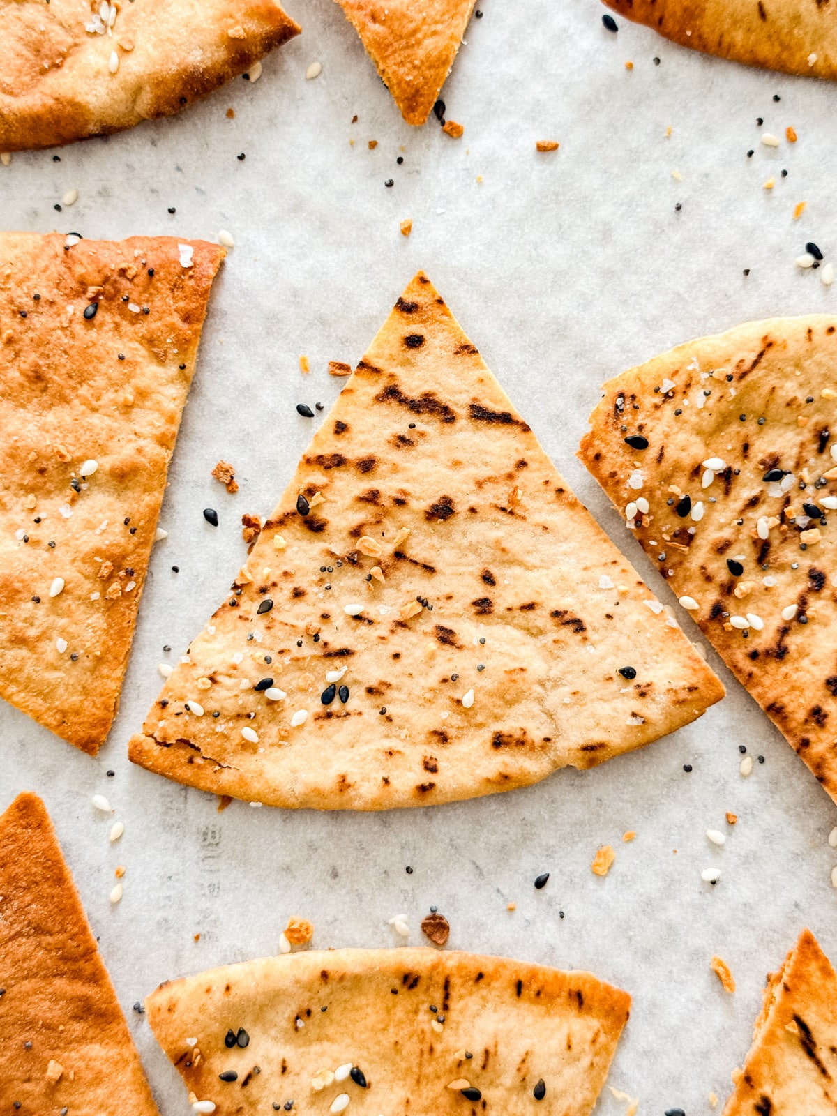 An overhead close up of the pita chips lined up on a pan.