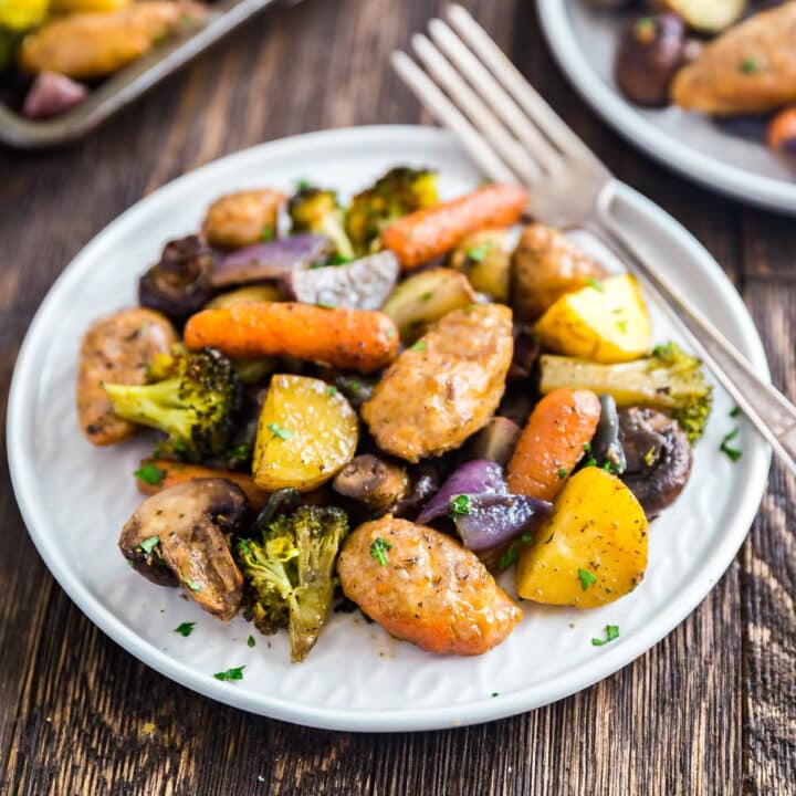 A plate of sausage and veggies with a fork on it.