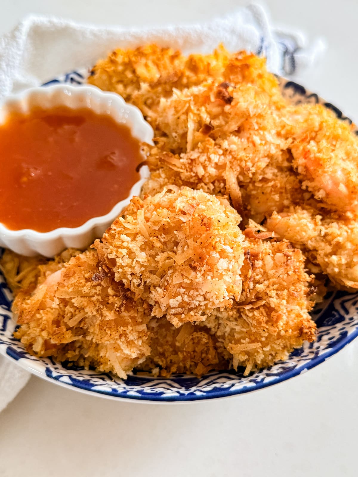 Coconut shrimp in a bowl with sauce.