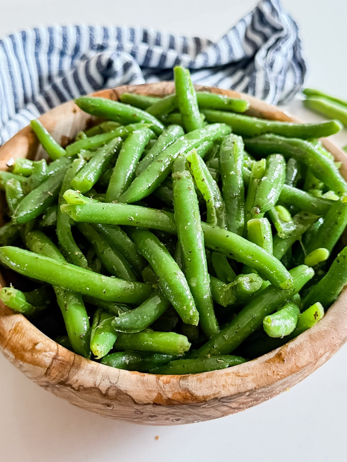 A close up image of a bowl of cold green bean salad.