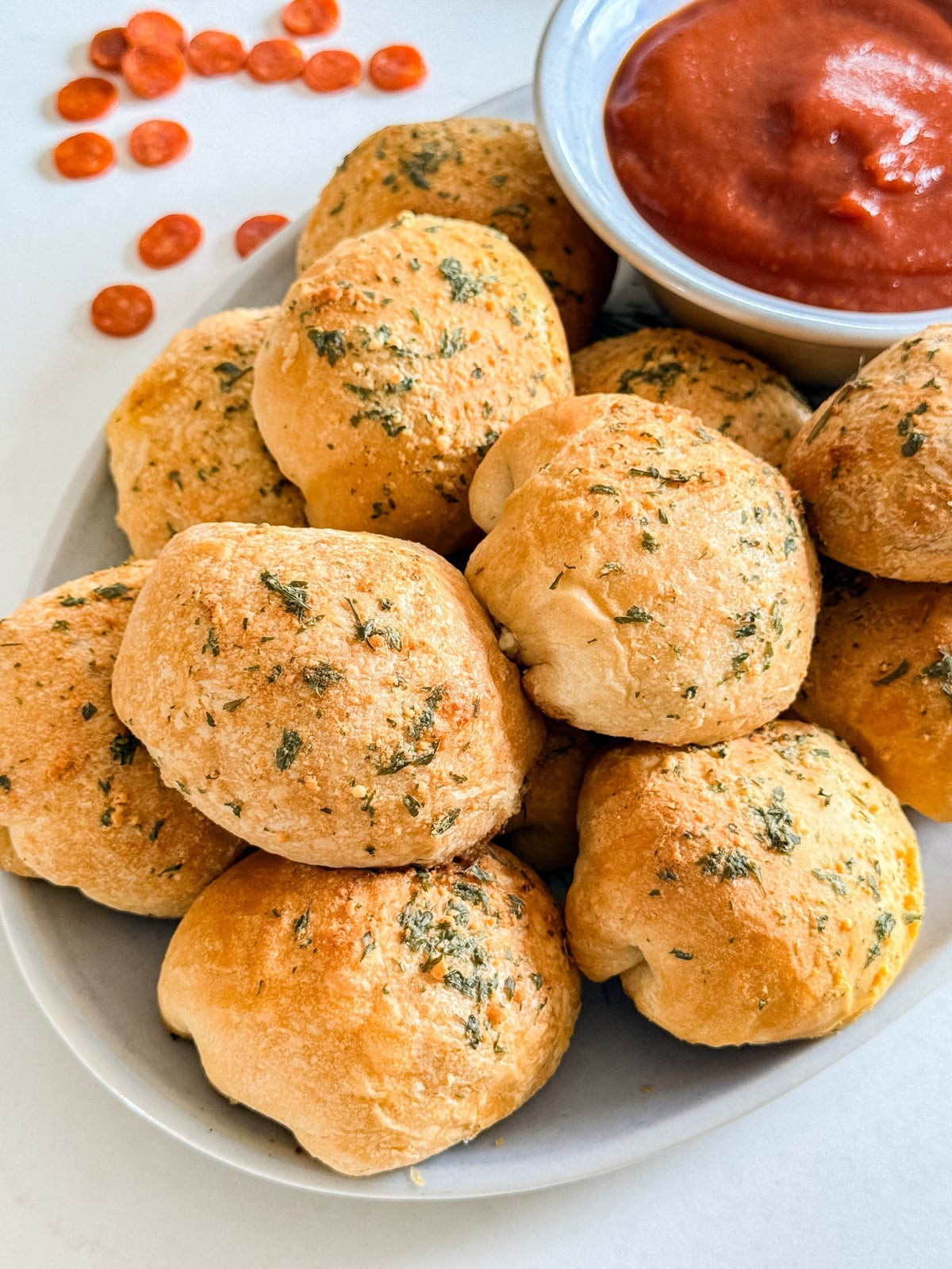 Pizza Bites on a plate with sauce n the background.