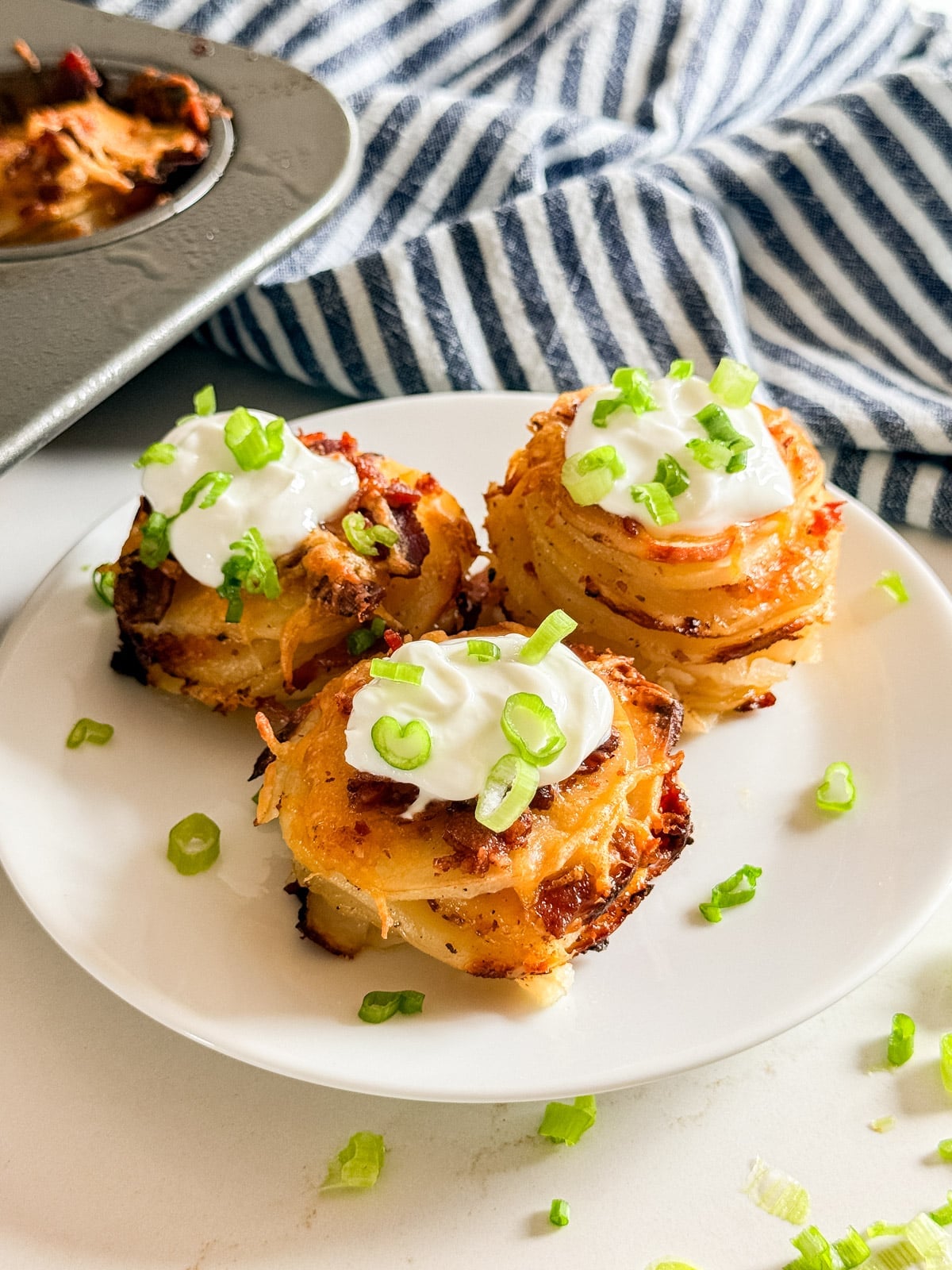 3 loaded potato stacks on a white plate.