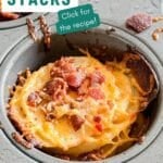 A close up of a potato stack in a muffin tin with cheese and bacon.