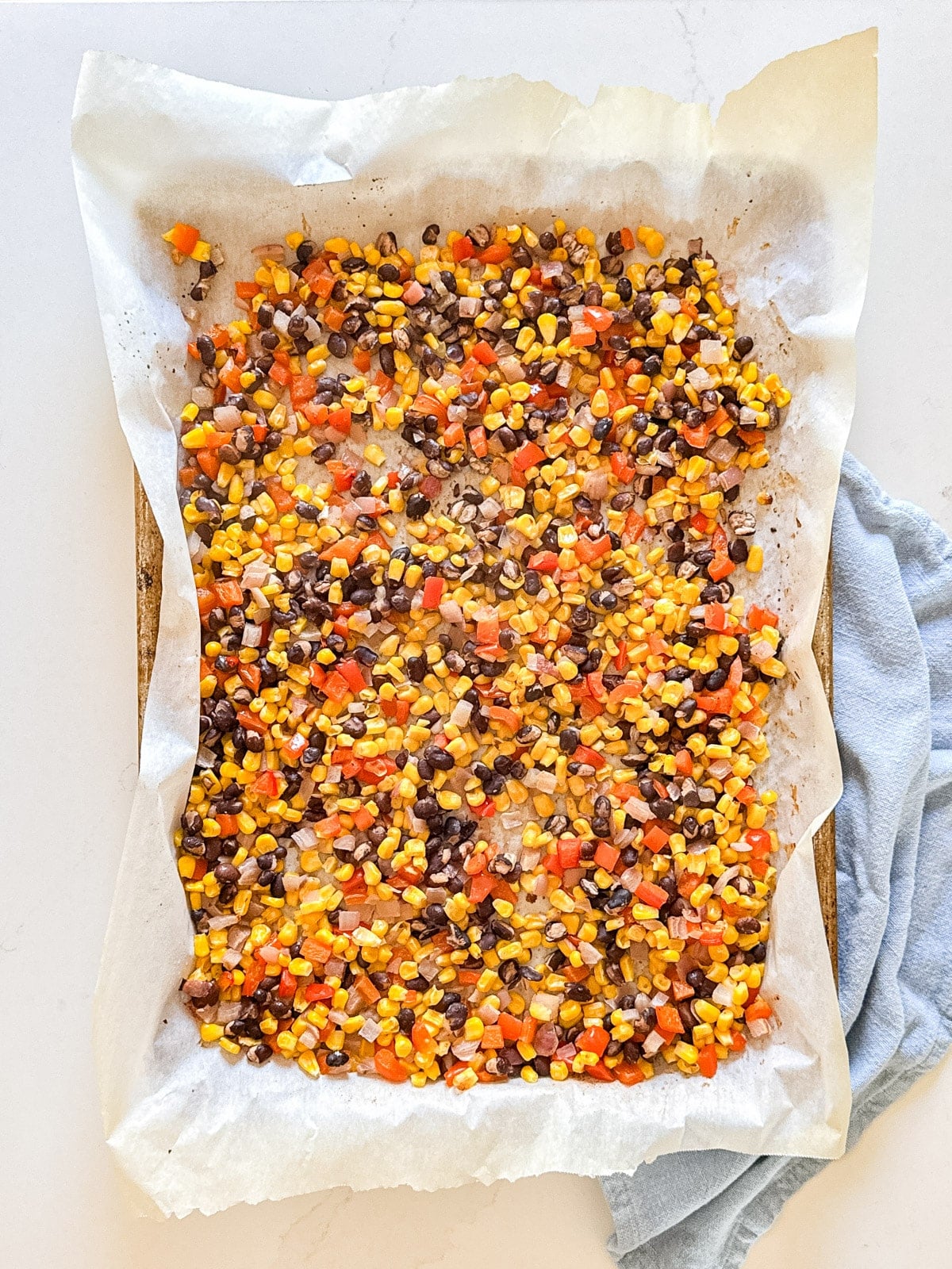 An overhead image of the corn salsa on a parchment lined baking pan.