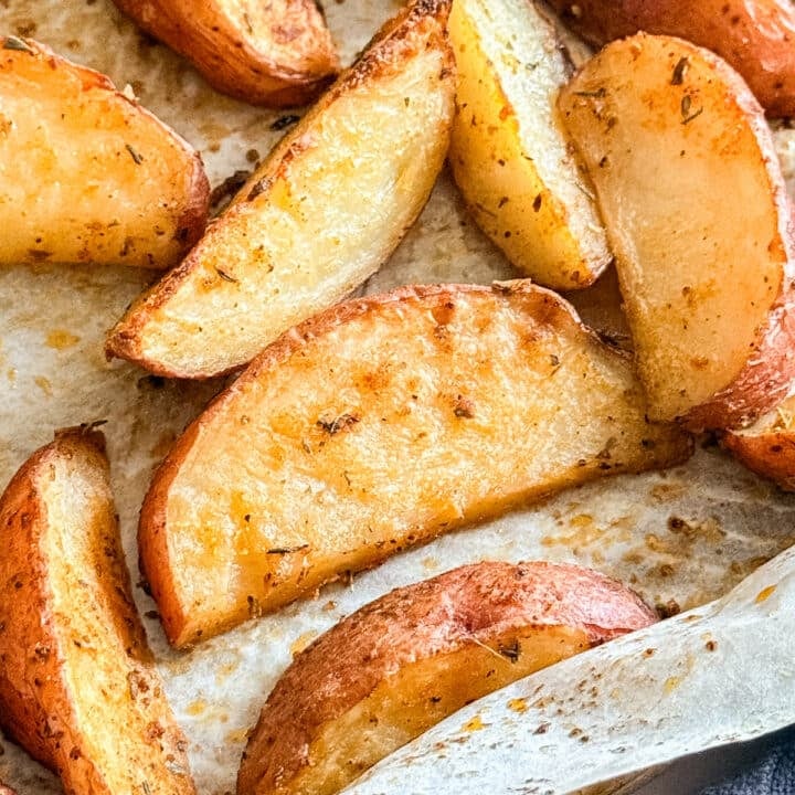 A close up of roasted red potatoes on a pan.