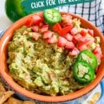 A bowl of guacamole with some chips and a checkered napkin behind it.