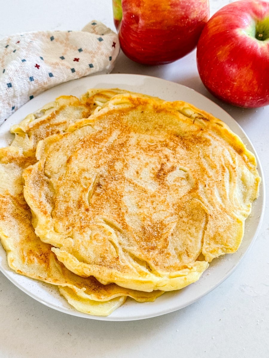 These are the most awesome breakfast recipe- they are thin and delicious and not too sweet. Soooooo good!! A close up image of apple pancakes recipe on a plate.