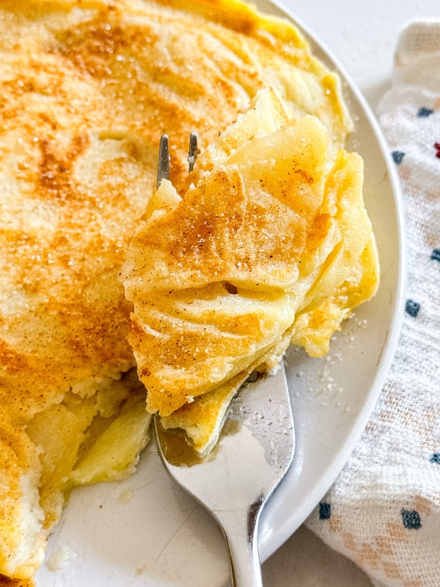 Grandma Hinz's Apple Pancakes | The Life Jolie A close up image of a bite of apple pancakes on a fork.