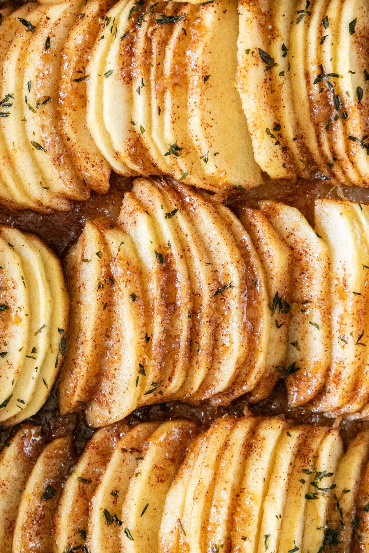 A super close up image of the glazed thinly sliced apples on the top of the bars.
