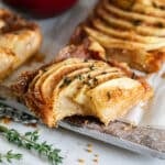 An Apple bar on a cutting board with a bite in it.