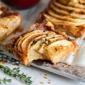 An Apple bar on a cutting board with a bite in it.