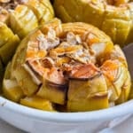 A close up of a bloomin' baked apple and oats in a pan.
