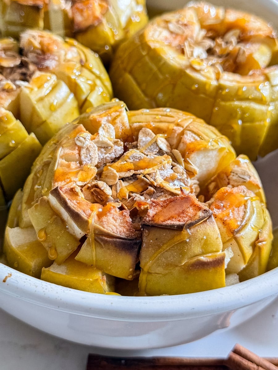 A close up of a bloomin' baked apple and oats in a pan.